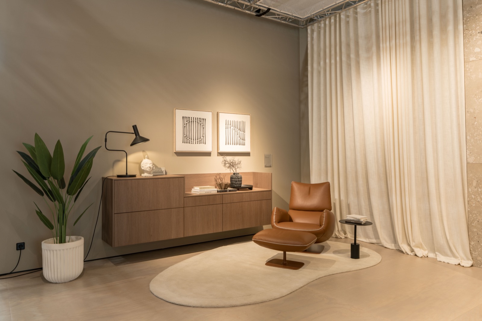 Wohnbereich mit Sideboard, Sessel und weichem Vorhang